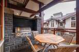 Enjoy outdoor living at its finest with this stunning property featuring a built-in grill and a cozy dining area.