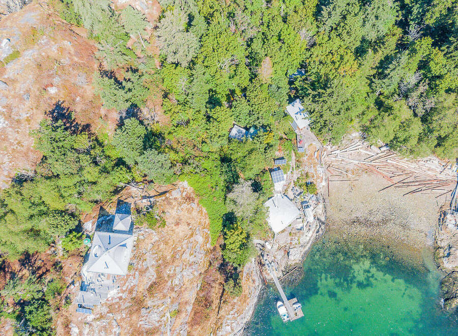 Discover a stunning coastal property nestled amidst lush greenery and rocky terrain.