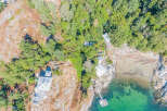 Discover a stunning coastal property nestled amidst lush greenery and rocky terrain.
