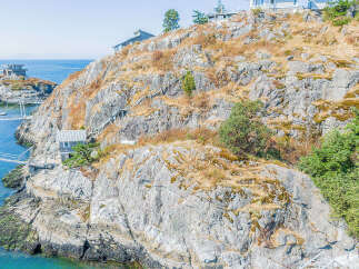 Discover a stunning coastal retreat nestled on a rocky hillside with breathtaking ocean views.