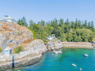 Discover a stunning waterfront property nestled on a rocky coastline, offering unparalleled views and privacy.