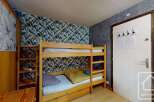 Discover this cozy bedroom featuring a charming bunk bed, perfect for accommodating guests or family.