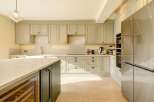 This stunning kitchen boasts a modern design with sleek cabinetry and a spacious layout, perfect for culinary enthusiasts.