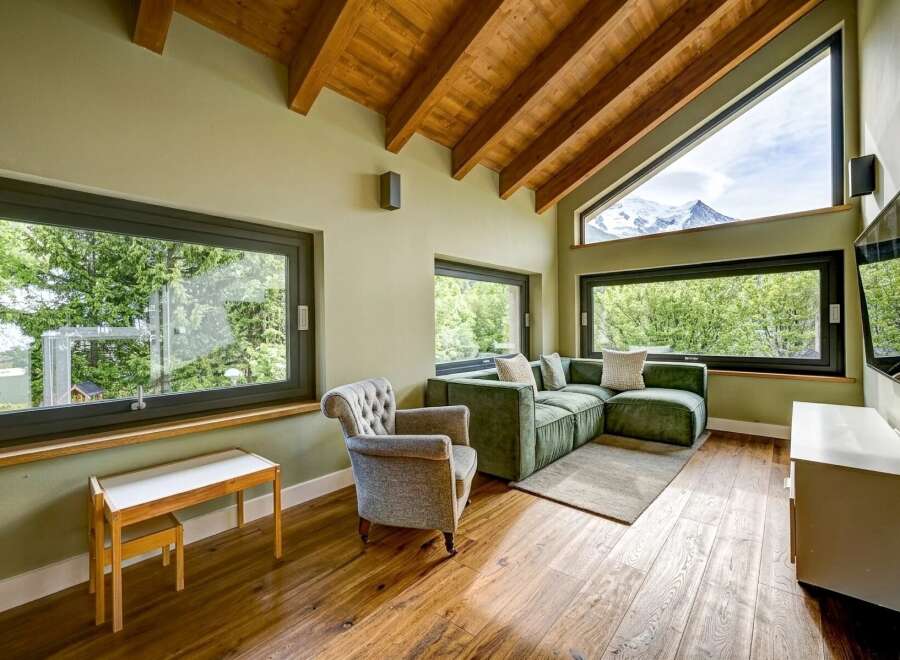 Experience luxury living in this stunning property, featuring a spacious living room with large windows that offer breathtaking views of the surrounding landscape.
