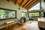 Experience luxury living in this stunning property, featuring a spacious living room with large windows that offer breathtaking views of the surrounding landscape.