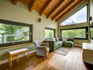 Experience luxury living in this stunning property, featuring a spacious living room with large windows that offer breathtaking views of the surrounding landscape.