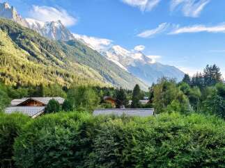 Experience the charm of alpine living with this stunning property nestled amidst lush greenery and majestic snow-capped mountains.