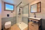 Step into this modern bathroom, featuring a sleek glass shower enclosure and stylish vanity.