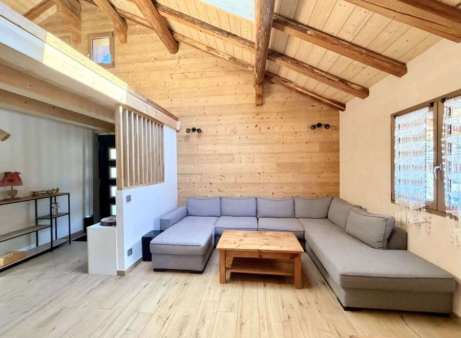 Discover the charm of this cozy living space, featuring a unique wooden ceiling and walls that create a warm and inviting atmosphere.
