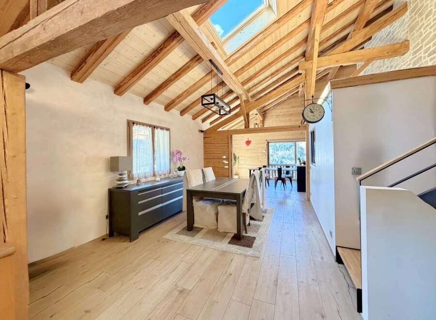 This stunning property boasts a unique architectural design with exposed wooden beams and a skylight, creating a bright and airy atmosphere.