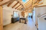 This stunning property boasts a unique architectural design with exposed wooden beams and a skylight, creating a bright and airy atmosphere.
