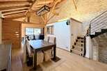 This stunning property boasts a warm and inviting interior with exposed wooden beams and a stone accent wall.