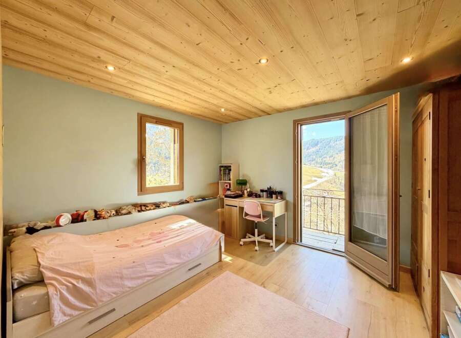 This charming bedroom boasts a cozy atmosphere with its wooden ceiling and flooring.