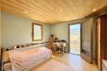 This charming bedroom boasts a cozy atmosphere with its wooden ceiling and flooring.