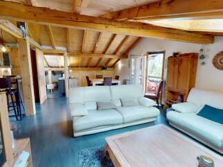 This stunning property boasts a warm and inviting living space with exposed wooden beams and a cozy atmosphere.