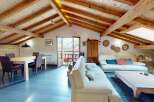 Discover the charm of this stunning property, featuring a beautifully designed living space with exposed wooden beams and a vaulted ceiling.
