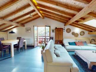 Discover the charm of this stunning property, featuring a beautifully designed living space with exposed wooden beams and a vaulted ceiling.