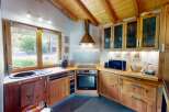 This charming kitchen boasts a warm and inviting atmosphere with its wooden cabinets and exposed beam ceiling.