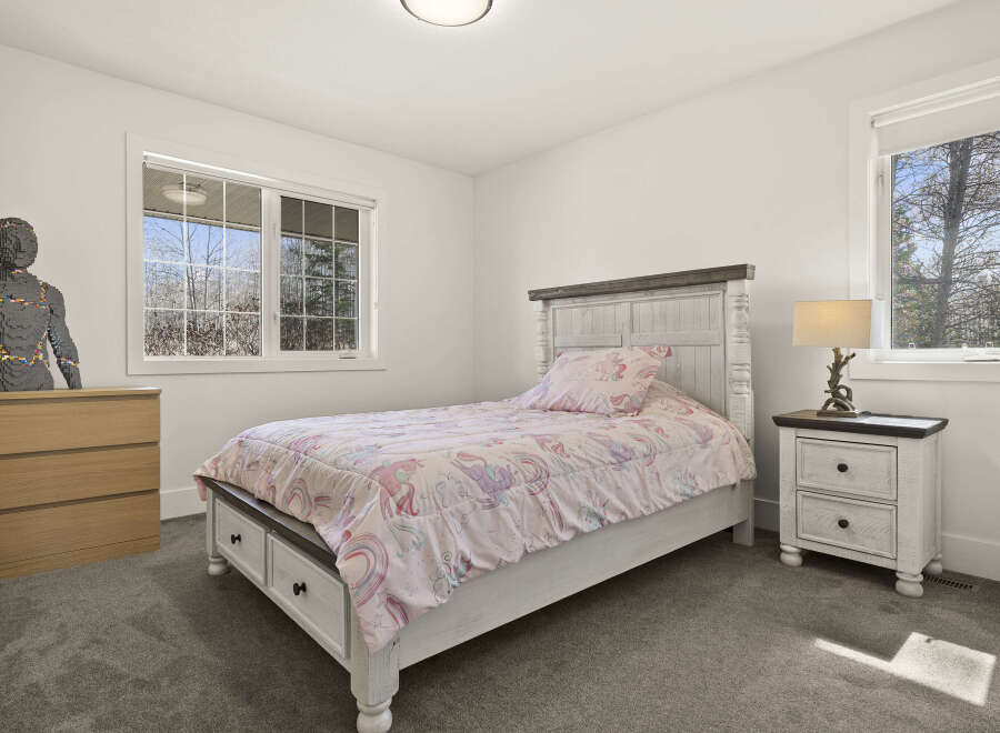 This charming bedroom features a cozy bed with a whimsical unicorn-themed comforter, perfect for a child's space.