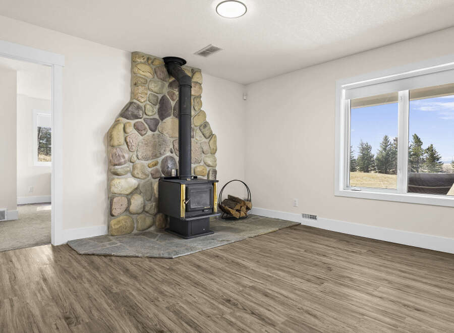 This inviting living space features a stunning stone fireplace, perfect for cozy evenings.