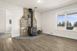 This inviting living space features a stunning stone fireplace, perfect for cozy evenings.