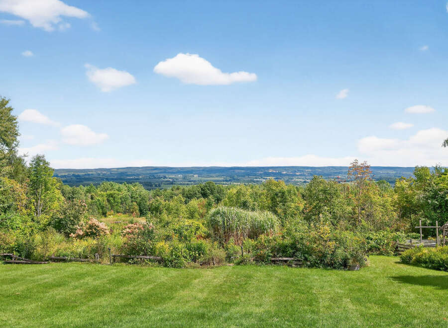 Enjoy breathtaking views from this stunning property! This expansive estate features lush green lawns, mature trees, and a serene natural landscape.
