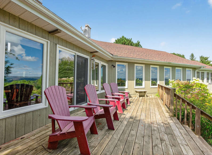 Enjoy the serene beauty of this stunning property featuring a spacious deck perfect for relaxation and entertaining.