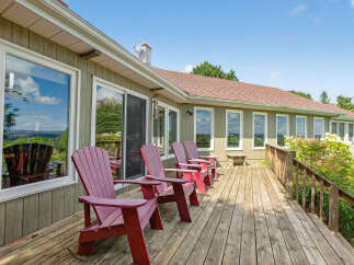 Enjoy the serene beauty of this stunning property featuring a spacious deck perfect for relaxation and entertaining.