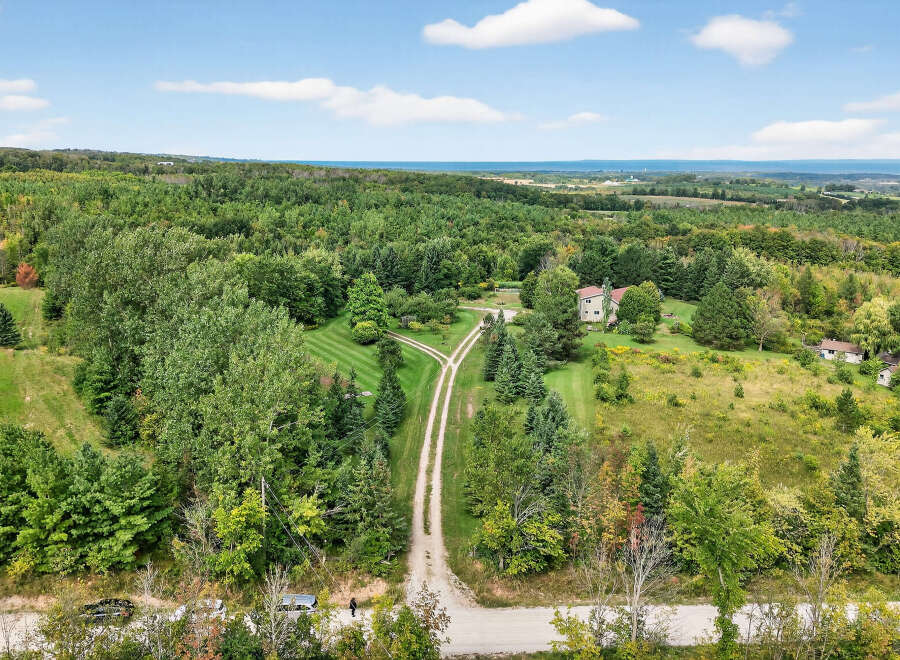 Discover your dream property! This stunning estate boasts a private, tree-lined driveway leading to a beautiful home.