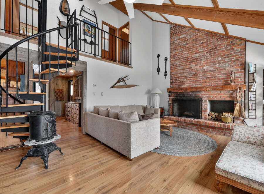 Step into rustic charm with this stunning property, featuring a cozy living room with a brick fireplace, perfect for those chilly evenings.
