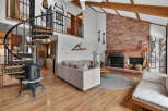 Step into rustic charm with this stunning property, featuring a cozy living room with a brick fireplace, perfect for those chilly evenings.