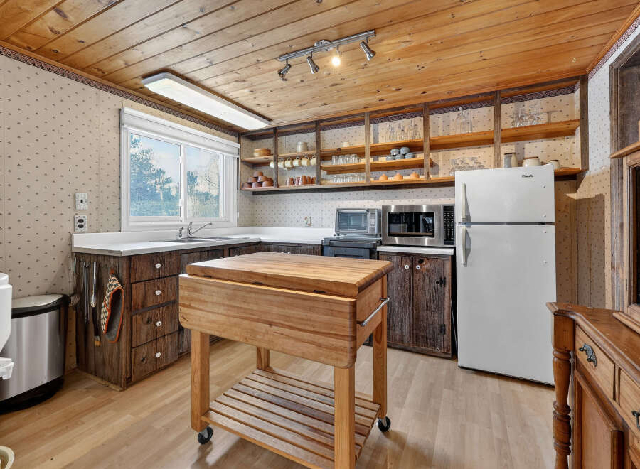 This charming kitchen boasts a rustic aesthetic with its wooden cabinetry and butcher block island.
