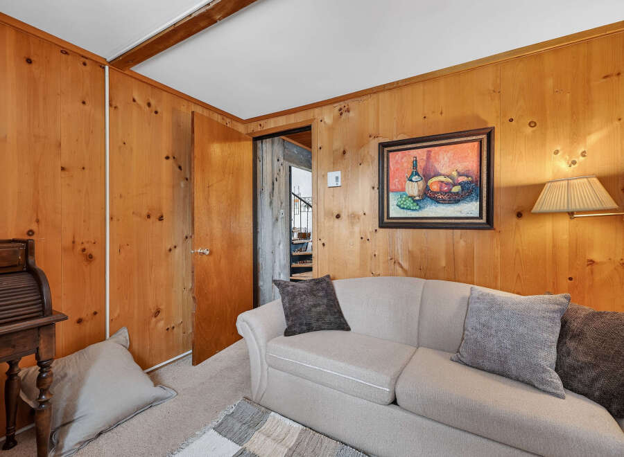 Step into this inviting living space, featuring warm wood paneling that exudes a cozy ambiance.
