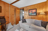 Step into this inviting living space, featuring warm wood paneling that exudes a cozy ambiance.