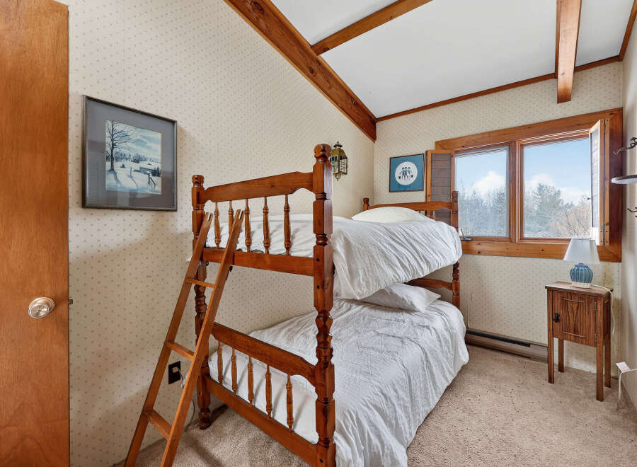 This charming bedroom features a cozy bunk bed, perfect for a vacation home or a kid's room.