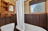 Step into this charming bathroom featuring a classic clawfoot tub and a vintage wooden vanity.
