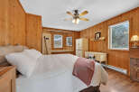 Step into this cozy bedroom featuring warm wood paneling and a comfortable bed.