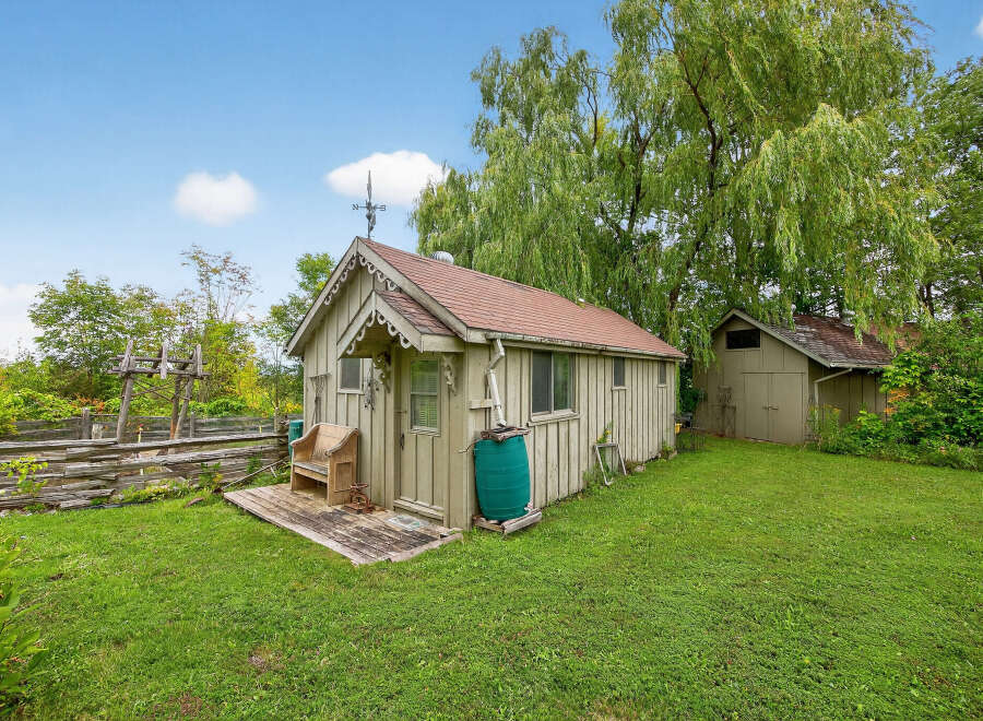 Charming countryside retreat! This property features a quaint shed with a rustic design, perfect for storage or a workshop.