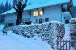 This charming stone house is nestled in a snowy mountain setting, offering breathtaking views.
