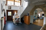 This charming home features a spacious entryway with ample storage, a stunning stone archway leading to the living area, and a beautiful wooden staircase.