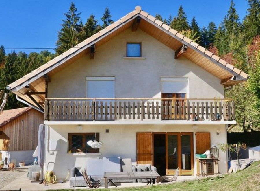 Charming chalet nestled in the French Alps, boasting a spacious balcony with mountain views and a private patio perfect for outdoor relaxation.
