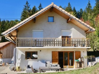 Charming chalet nestled in the French Alps, boasting a spacious balcony with mountain views and a private patio perfect for outdoor relaxation.