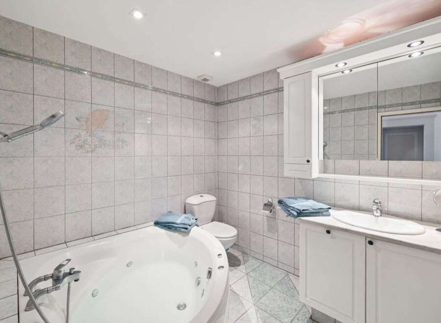 This stunning bathroom features a luxurious jacuzzi tub, perfect for relaxing after a long day.