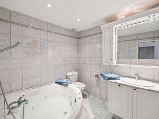 This stunning bathroom features a luxurious jacuzzi tub, perfect for relaxing after a long day.