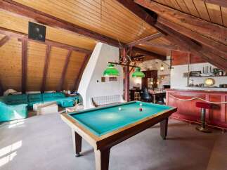 This stunning property features a unique loft-style design with exposed wooden beams and a cozy atmosphere.