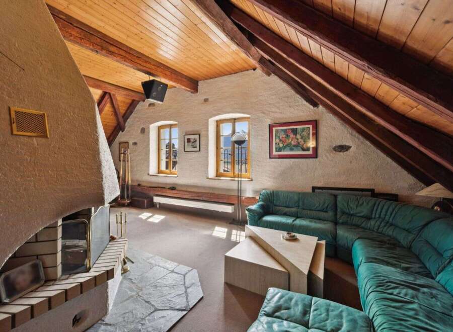 Discover the charm of this unique property featuring a cozy living room with a stunning fireplace and exposed wooden beams.