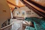 Discover the charm of this unique property featuring a cozy living room with a stunning fireplace and exposed wooden beams.
