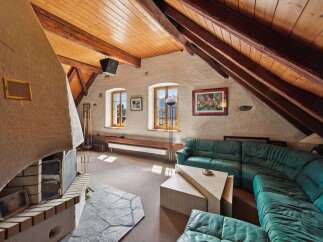 Discover the charm of this unique property featuring a cozy living room with a stunning fireplace and exposed wooden beams.