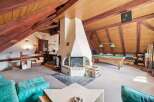 This stunning property boasts a unique and spacious interior with exposed wooden beams and a cozy fireplace.