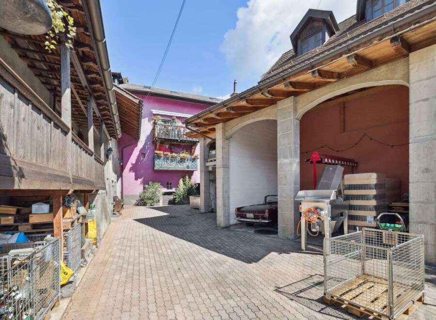 Discover the charm of this unique property, featuring a classic car parked in a covered area.